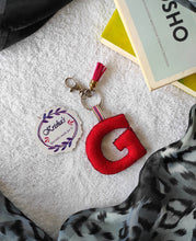 Load image into Gallery viewer, Key ring bag charm. Cute bag charm with stuffed alphabet. Hand bag charms. Felt bag charm. Unusual bag charm. Pink bag charm. Bag charm with lobster claw clip. Luxury bag charm. Tessel bag charm.